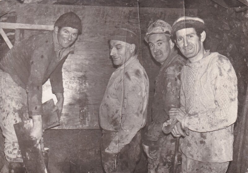 Brothers Dinnie Gallagher (far left) and John Gallagher (far right) originally from Tully near Dungloe pictured with Mick Durkin (from County Mayo) and John Floyd (from Ballybofey) working for the Cementation company on the interceptor sewer in Seafield, Edinburgh circa 1966.  The dangerous nature of their working environment is conveyed by the condition of their work clothes and the lack of personal protective equipment. (Image courtesy of Mary Gallagher)