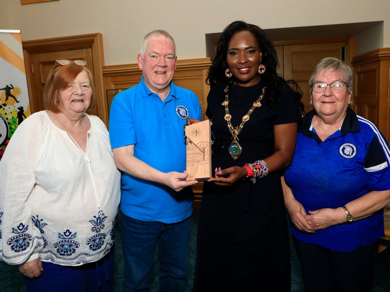 Mayor Lilian Seenoi Barr makes a presentation to Trojans FC vice-president Raymond Carton, in recognition of his contribution to Grass Roots Football for over 50 years, at a reception held in the Mayor's Parlour. Included on left is Raymond's sister Annette, and on right Kitty Wright, Trojans FC president.