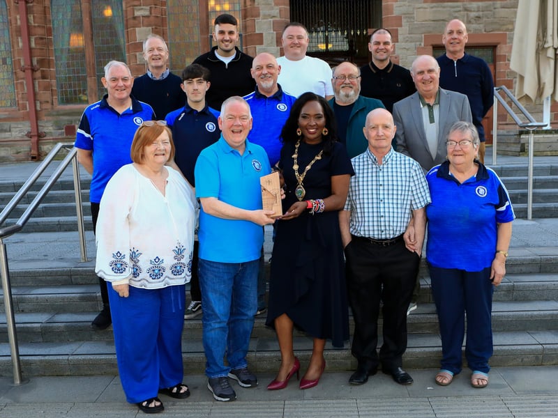 Mayor Lilian Seenoi Barr makes a presentation to Trojans FC vice-president Raymond Carton, in recognition of his contribution to Grass Roots Football for over 50 years, at a reception held in the Mayor's Parlour. Included are club members. (Photos - Tom Heaney, nwpresspics)