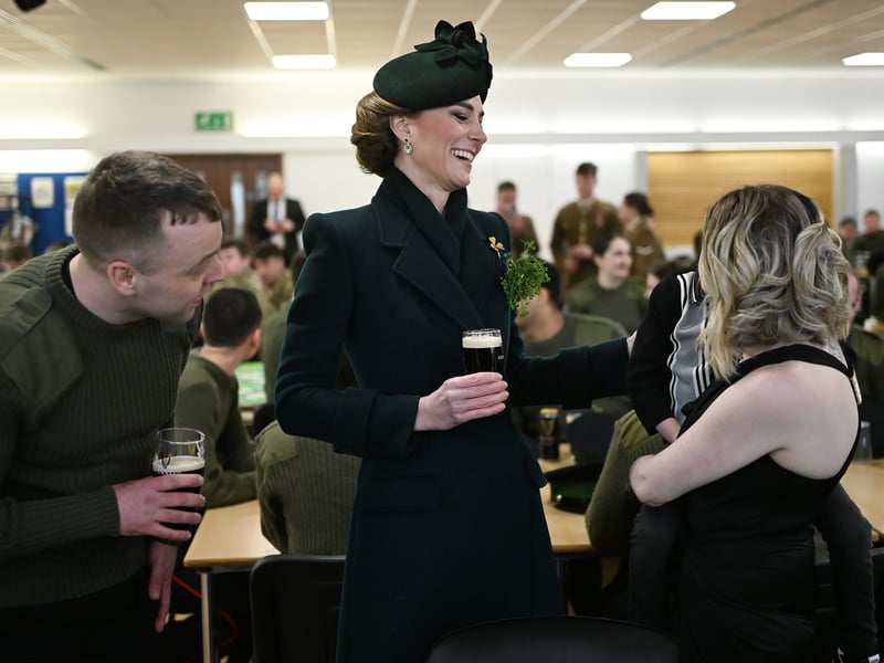 Dressed in green, Kate wore a shamrock as she met service personnel.