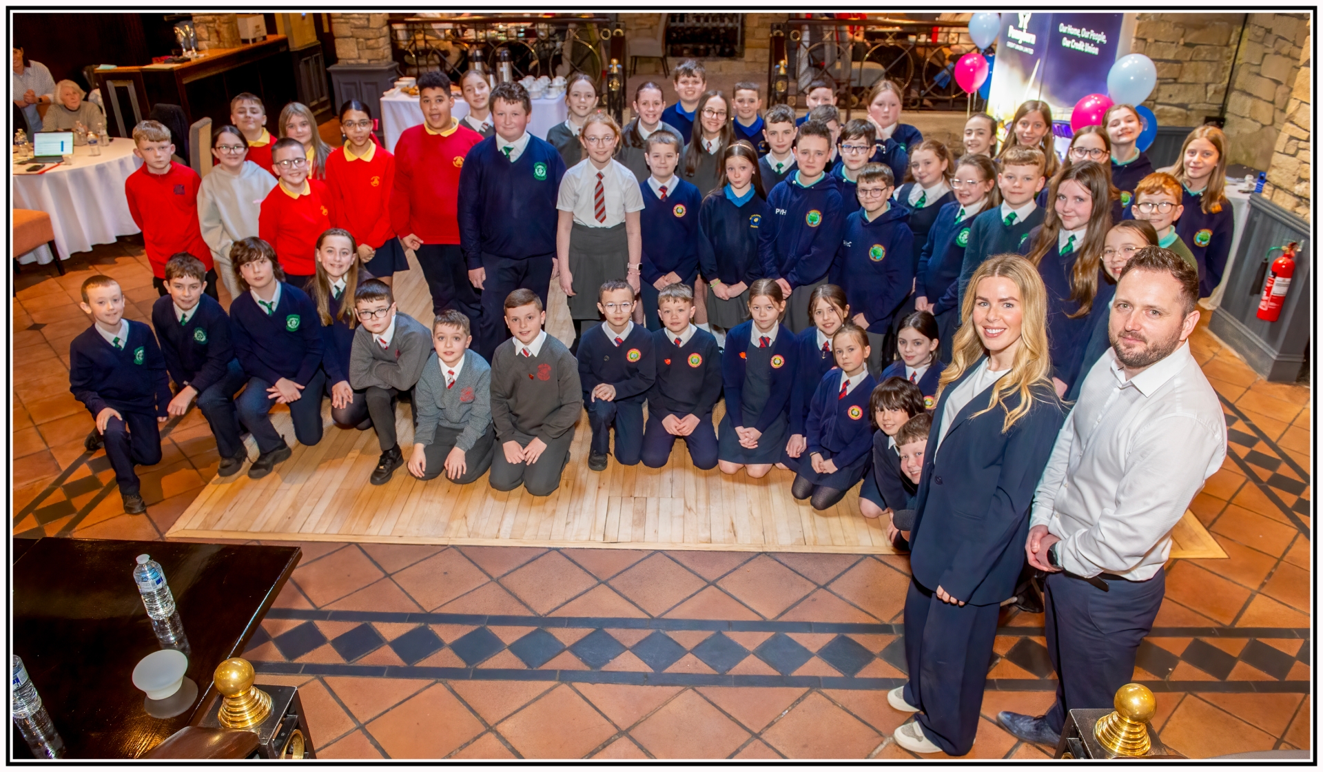 Primary School pupils alongside Pennyburn Credit Union Manager, Frank Doherty, and Marketing Executive, Laura Brown.