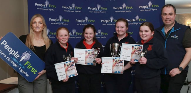 Competition B trophy winners for 2024, Scoil Fionntain Naofa, Shanahoe. Pictured are: Mia Ryan (People First CU) with team members Emmy Mc Donald, Nicole Walsh, Meadhbh Doogue and Julie Rohan with Sean Dunne (CEO People First CU).