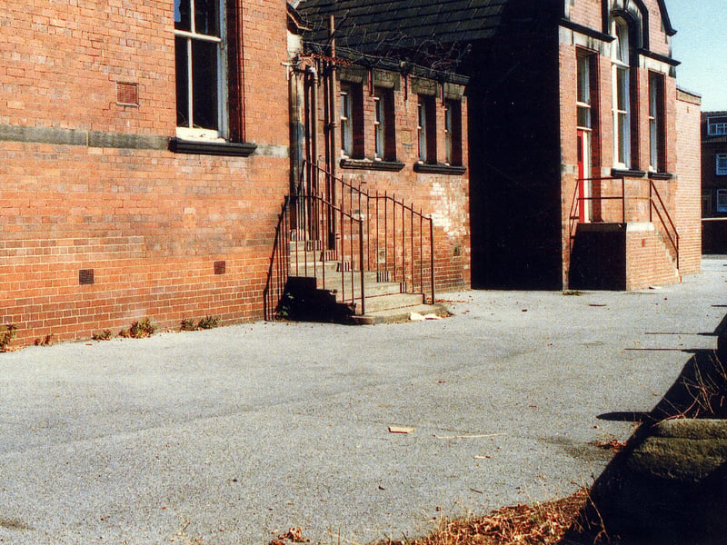 Cross Flatts Park School on Harlech Road, probably taken around 1989 at the time that it was Cross Flatts Park Middle. Previously it had been a primary school, with separate buildings for infants and juniors; this was the rear entrance to the infants department, facing Harlech Mount. The houses in the backround are on Harlech Road.