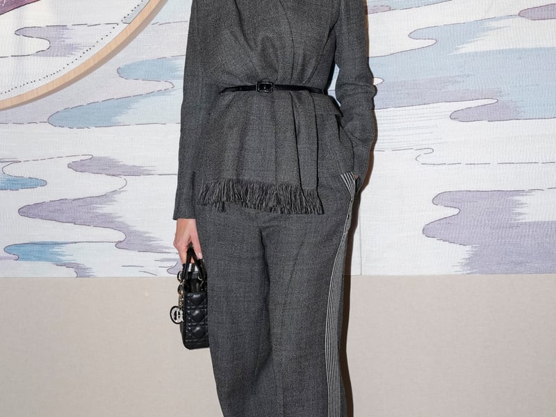 Model and actor Pamela Anderson, 57, wore a slate grey suit, with an Alice band and veil and matching Lady Dior bag.