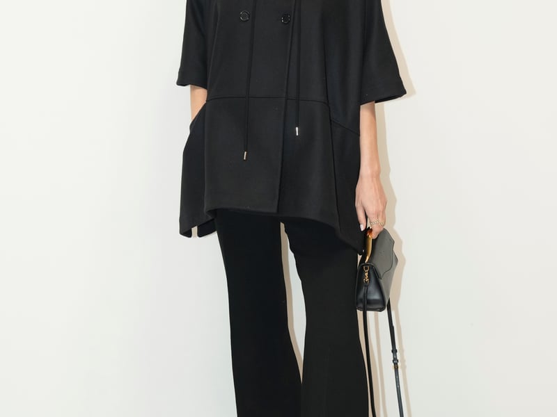Socialite Poppy Delevingne, 38, opted for a more casual look in a hooded black cape and longline flares.