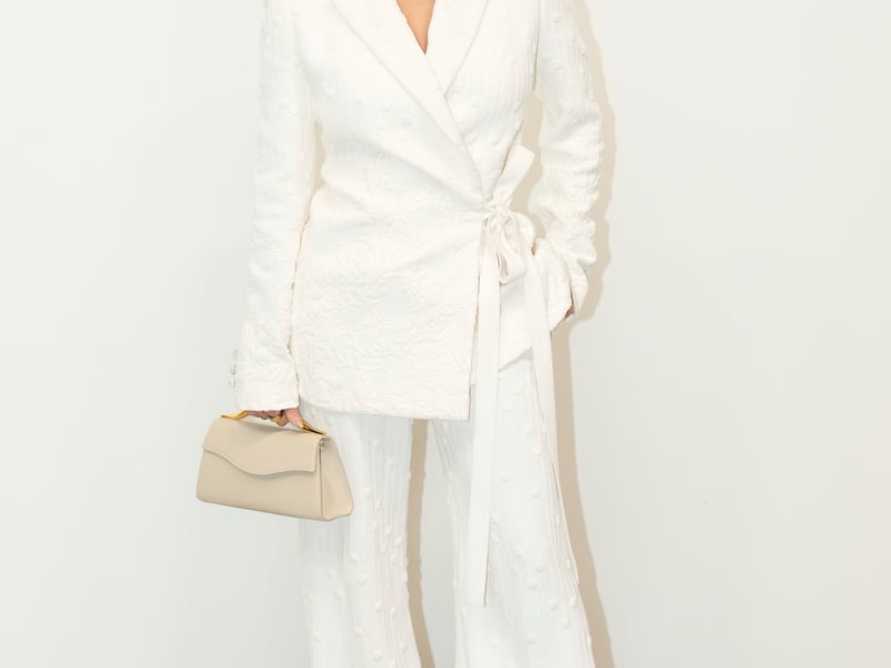 Actor Eva Longoria, 49, wore a white floral macramé suit with wide legs and a cream clutch.