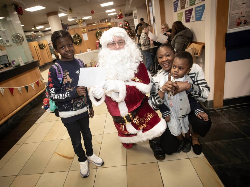Santa Claus receiving letters from Kareemai, Koke and Faiz Ali at the Derry Credit Union 'Santa Saturday' event.