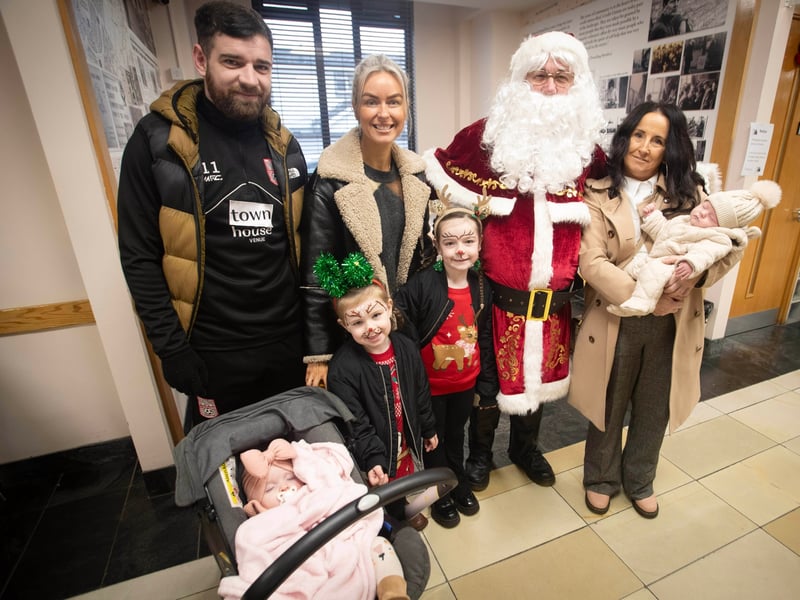The McIntyre family - Paul, Alicia, Deirdre, Carol, Evie, Molly and Kade get a photo with Santa Claus on Saturday at the Derry Credit Union.