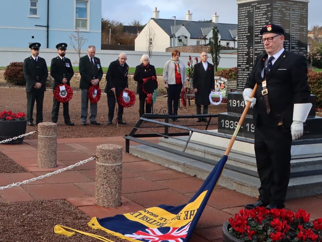 The annual Remembrance Day service in Ballycastle; the standard bearer is pictured with the standard lowered as a mark of respect.
