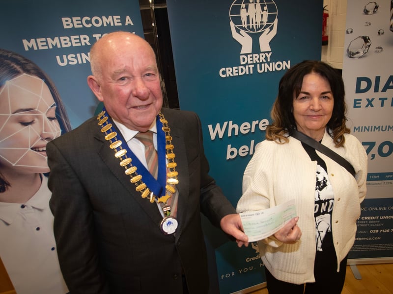 Derry Credit Union president Colm McCauley presenting the £500 prize to Charmaine Leonard at Monday night's AGM.