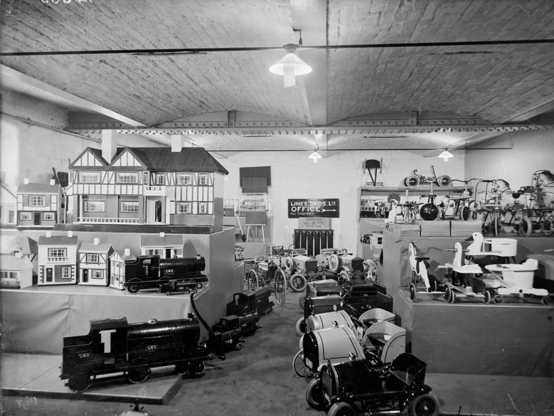 Inside the Triang Toy Shop on Oldham Road, Manchester, in 1927, with doll houses, trains and pedal cars among the items on display