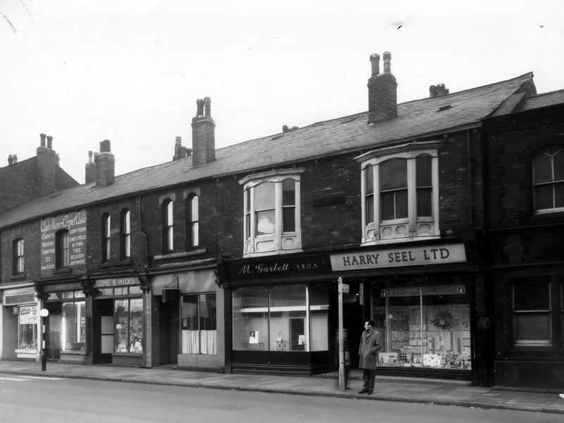 A parade of shops on Hunslet Road in November 1960. On the left is the Newmac Electric store with the Clyde Manor Carpet Co. Ltd on the right at number 246. At number 244 on the right is Cove and Hicks with a fish and chip shop at number 242 on the right. At number 240 is Micheal Garbett FBOA opticians with the Harry Seel Ltd decorating shop at number 238 on the right