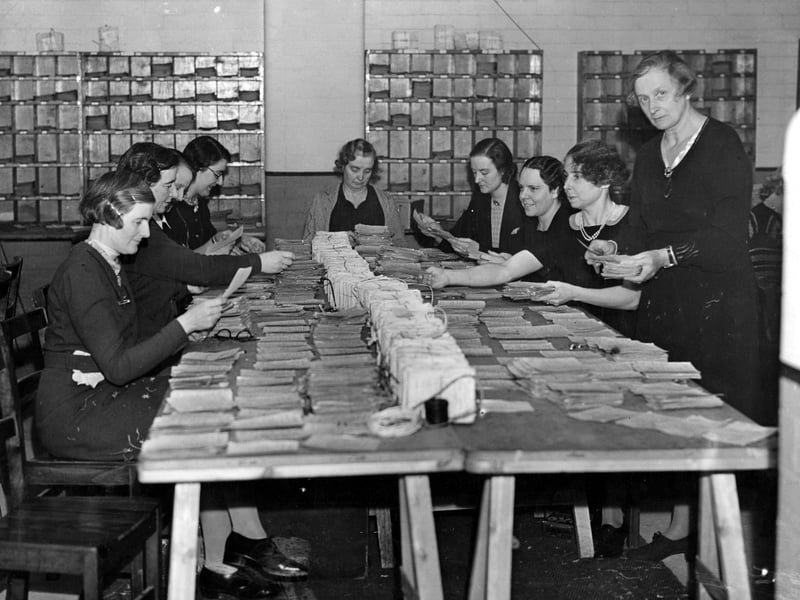 Women sat around a large table preparing the first ration books in November 1939.