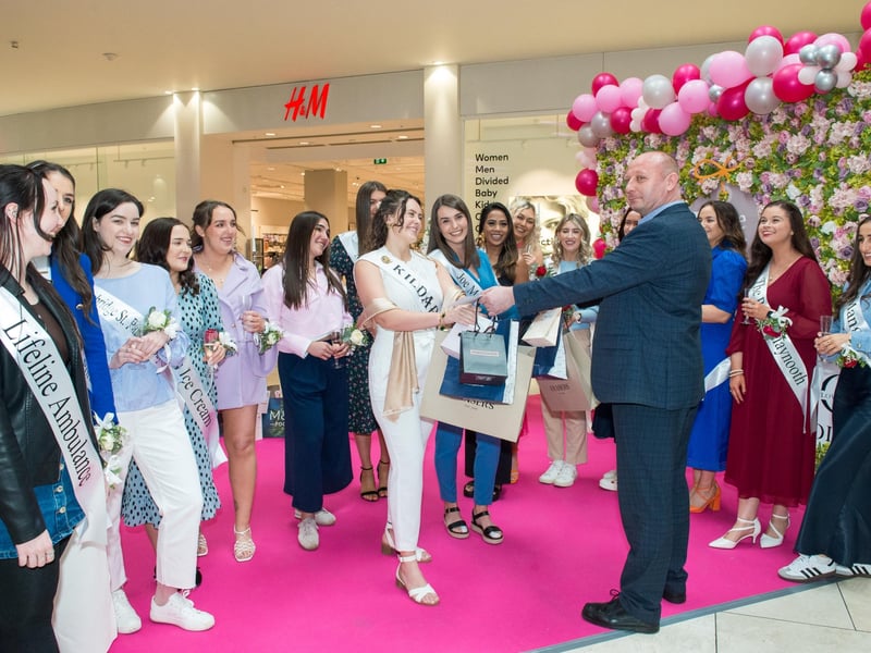 Piotr assistant centre manager presenting the goodie bags to the Roses.