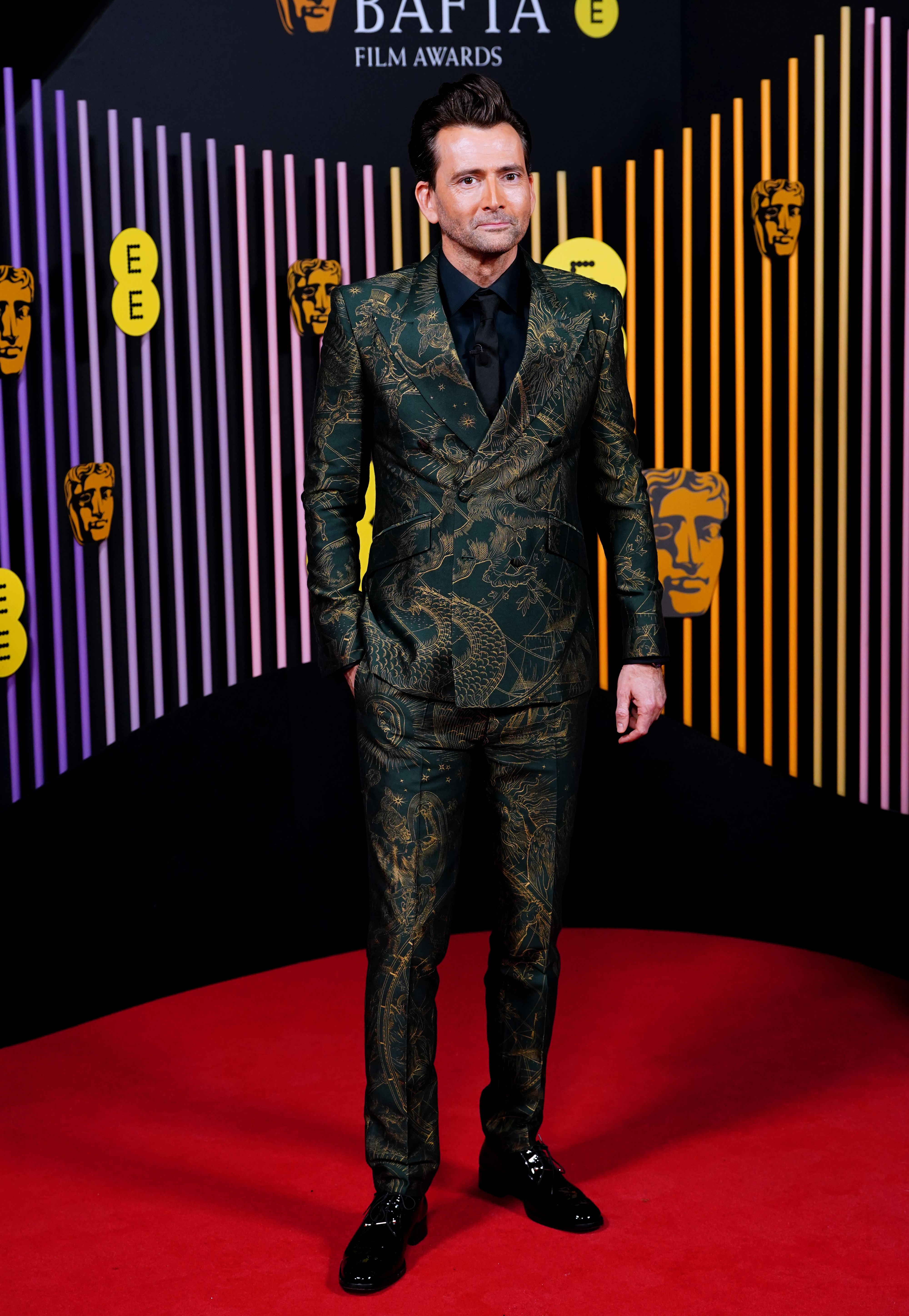 Instead, he walked the red carpet in a green and gold suit which appeared to feature an intricate horoscope-inspired pattern.