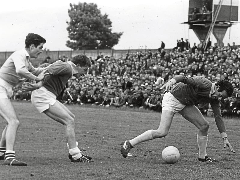 Caption: Longford's Mick Hopkins stoops low to pick up the ball during his side's 1-12 to 0-12 win over Dublin in the Leinster SFC quarter-final on June 2, 1968 in O’Connor Park, Tullamore. Team mate Sean Donnelly is pictured holding off Dublin defender Bill Casey (left).