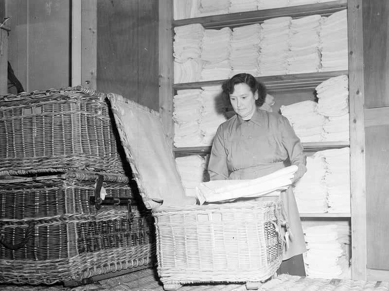 Mrs M Cameron prepares sheets, pillow-slips and towels for a British Railways night sleeper train in 1956