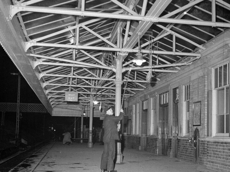A porter turns off gas lamps at the deserted Peebles Railway Station in 1962