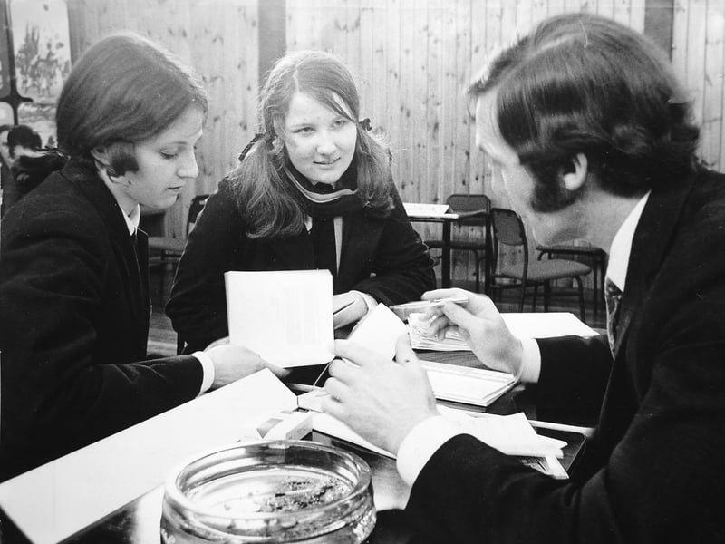 March 1971: A careers convention at Wrekin Youth Centre, organised by the Wrekin Youth Employment Committee for local schools. Pictured are Wellington schoolgirls Marilyn Gough and Elaine James speaking with Mr H Clayton-Jones of Walker Technical College. Details on the table, including an ashtray and a packet of Embassy cigarettes with matches, offer a glimpse into the era.
