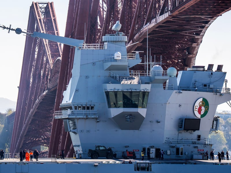 HMS Queen Elizabeth passes under the Forth Bridge heading out to sea after leaving Rosyth, Fife, following an extended maintenance period.
Picture: Jane Barlow/PA Wire