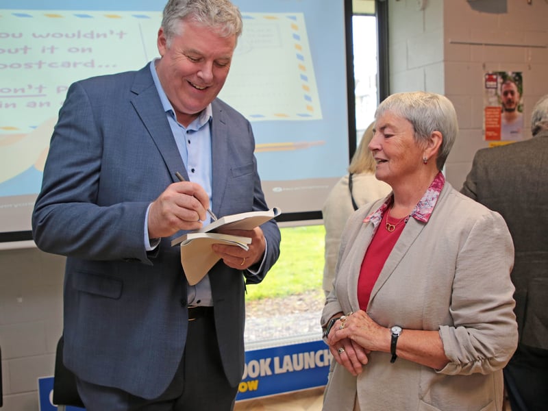 Caption: Ciaran Mullooly signing a copy of his new book for Jean Duncan in Longford library Picture: Shelley Corcoran