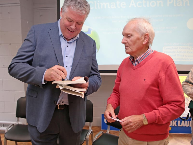 Caption: Ciaran Mullooly signs his book for Peter Duffy Picture: Shelley Corcoran