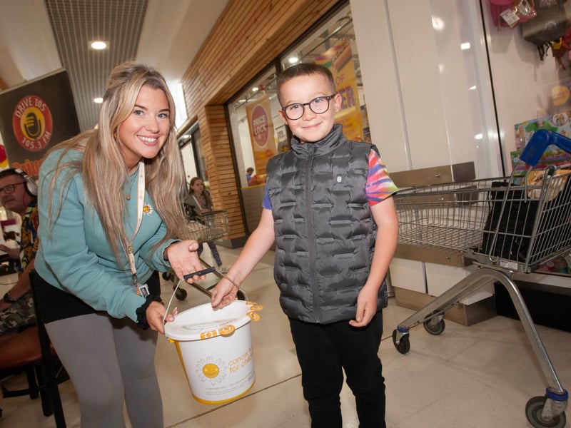 Molly Wilson, Cancer Fund for Children accepts a donation from young Finn Clarke at Friday's Lisnagelvin Shopping Centre's Annual Great Family Fun Day.