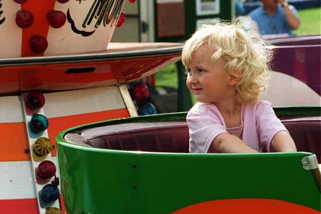 Anyone for tea? This little girl sits and waits for her turn in a giant tea cup.