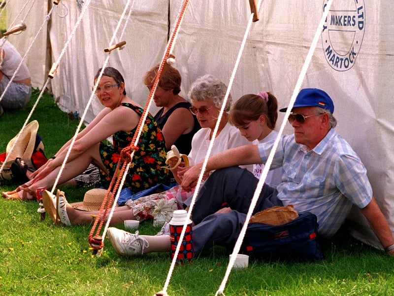 Visitors to Leeds Show in August 1997 find the shady side of a marquee a good resting place to escape the heat of the sunshine.