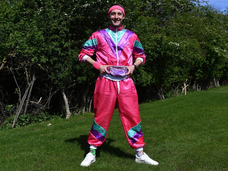 A fan shows off his pink and purple man bag.