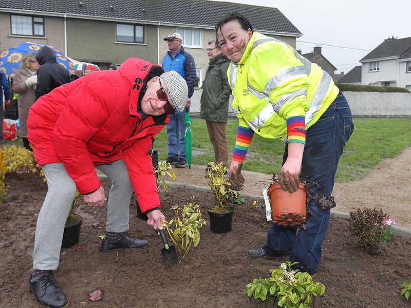 Veronica D'Ambra is pictured helping Denis O'Connor put down a plant in memory of his late wife Nessa O'Connor.