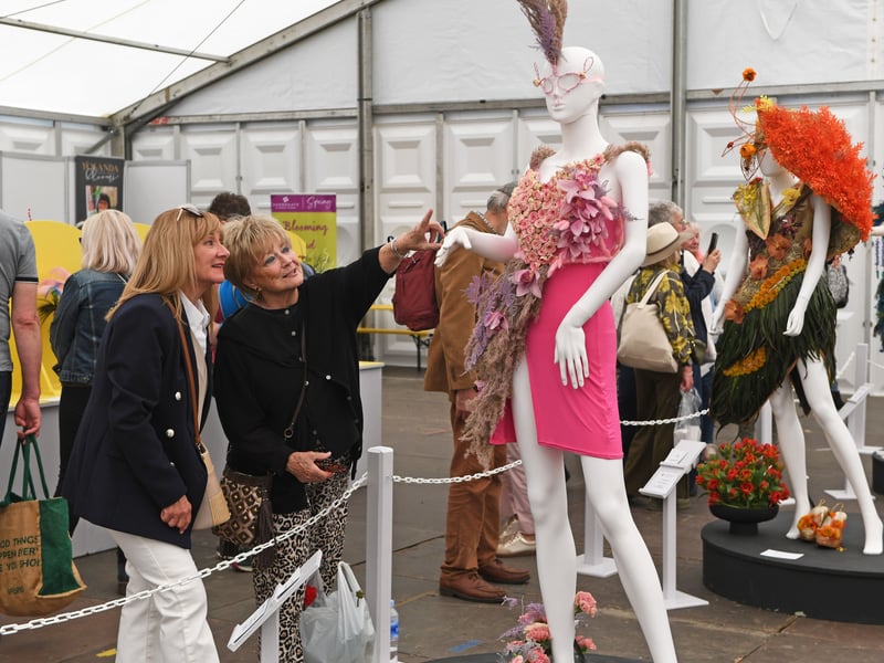 Visitors view the exhibits in the Floral Art Pavilion.