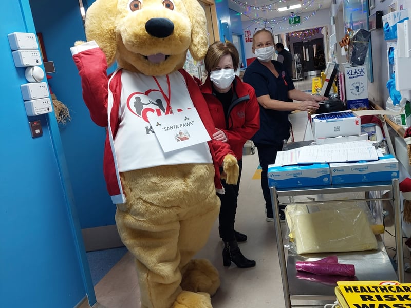Caption: Cian's Kennels mascot 'Santa Paws' and Evelyn Neary delivering Christmas goodie bags to sick children