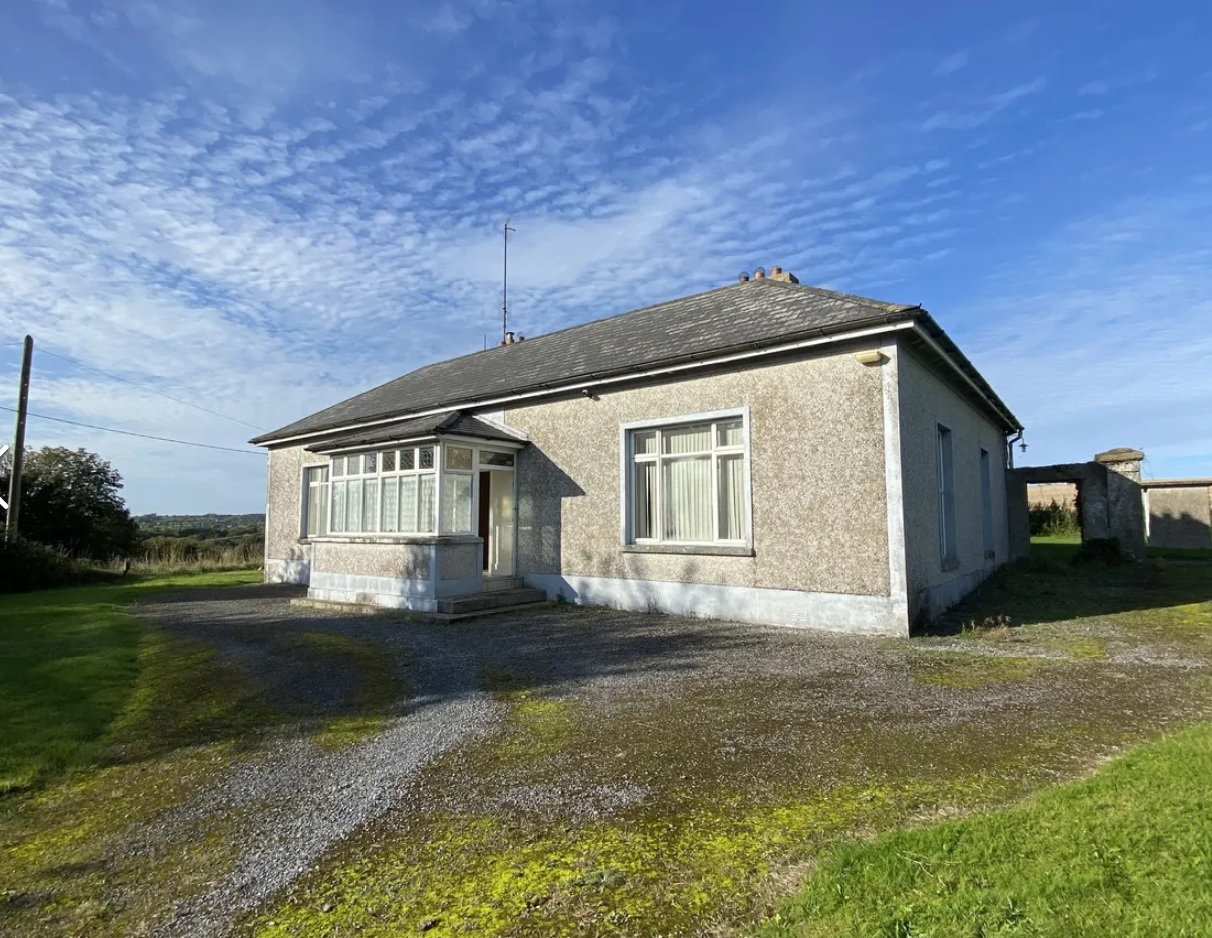 A period parochial house in rural Laois that would make an idyllic home is coming up for public auction. The parish house in the pretty village of Timahoe was a priests' home for over 100 years and oozes with character. Sized at a generous 2,100 sq ft, is packed with period features like large windows, fireplaces, timber floors and a shelved pantry. The house is being auctioned off on October 27 along with 1.3 acres of rolling fields, guided at €240,000. It is one of three lots, with Lot 2 offering 9.5 acres of agricultural land guided at €140,000 and Lot 3: the entire (Lot 1 & Lot 2) guided at €380,000.00. Bidders must register with Hennessy Auctioneers by October 25. "We are delighted to welcome to the market this fine single storey parochial house with small attic conversion majestically set on C. 1.3 acres overlooking the village of Timahoe. This property is located within close proximity to Timahoe Village in Laois. It is within walking distance to the church, school, local park and all local amenities. "The house is a 2 bedroom property built in the early 1900s extending to C. 2100 sq. ft. (which excludes the attic space) It  contains: Front porch Entrance hall 2 x sitting rooms Study/office 3 x storage rooms Private meeting room/ office Bathroom Kitchen Attic area contained in the original main house A lean to extension with 1 bedroom (with WC) Utility room. "Services: Oil fired central heating (not currently working), solid fuel stove, 4 x open fire places, mains water and septic tank (old style and located in close proximity to the property). "Outside: Pebble driveway, Gardens surrounding the property, 12ft x 20ft lean to stone building (derelict) and 50ft x 17ft lofted stone shed with high roof. "Lot 2. C. 9.5 acres of agricultural land guided at €140,000, is described as top quality arable land. It is presently in tillage production. It commands panoramic views of the countryside. As it is in a village setting it may have development potential." Click on NEXT below image to see dozens