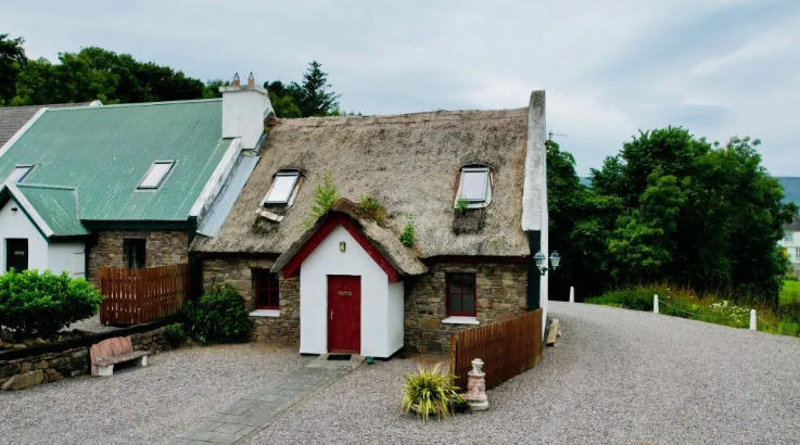 This beautiful three bedroom semi detached cottage is going on sale by Public Auction on Thursday July 28 starting at €100,000. Part of a small holiday home complex comprised of cottages with thatched, slate and corrugated roofs, situated in the heart of the pretty little village of Milltown in Co Kerry. The cottages offer attractive, traditional style, spacious living areas with double height ceilings, feature fire surrounds and wooden beams. Accommodation: - Ground floor: Living room with wooden floor/dining room with tiled floor. - Kitchen with tiled floor. 2 bedrooms: 1 double, 1 twin, both with wooden floor. - Bathroom with bath, shower attachment and toilet. - First floor: 1 double (5ft 6in) bedroom with wooden floor and en-suite shower room with toilet. CLICK ON THE ARROWS ABOVE TO TAKE A TOUR AROUND THE HOUSE    