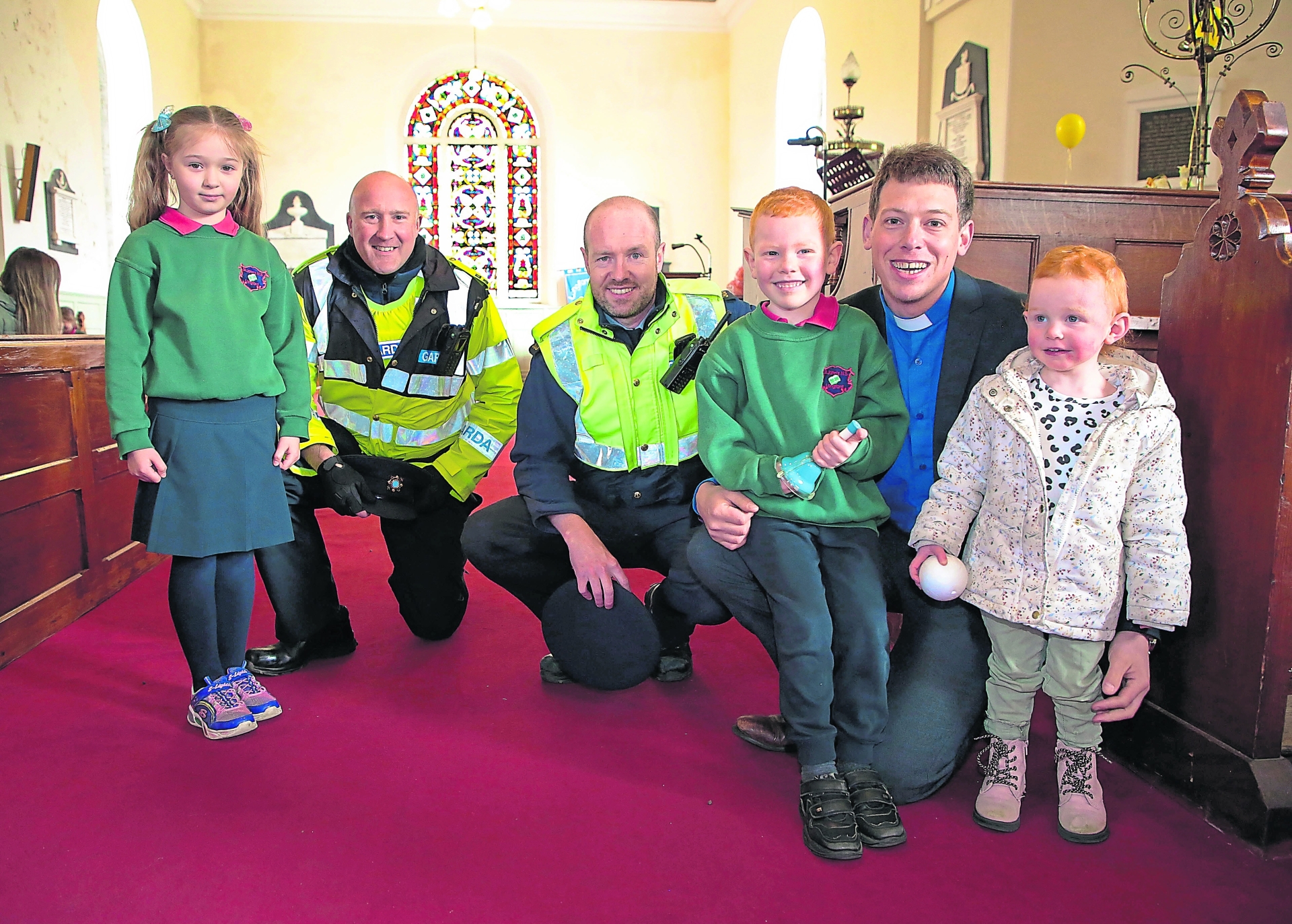 Sgt Darren Conlon, Gda Anthony Scanlon and Rev Simon Scott with children from the Junior Room St John’s National School celebrated ‘Our Easter Celebration’ on Wednesday, April 6. The school was led in their celebrations by Reverend Simon Scott. Easter is traditionally a time when we celebrate life, and this acted as the catalyst for the celebration to which available members of the emergency services were invited. The celebration was a fitting way to commemorate the invaluable contribution, dedication and heroism of emergency services personnel in protecting all of our lives during the pandemic. The day was made more special as it was the first whole school event enjoyed by the wider school community since the recent lifting of restrictions and its awarding of DEIS Urban Band 1 status. The children took centre stage on the day and impressed all in attendance with their singing and presentation of scripture readings. A number of children from each classroom, including the children from the Middle Room, under the direction of their teacher Clement Farrar, read self-composed prayers of thanks which were excellent. The altar was adorned with beautiful artwork completed by the children. Acting Principal, Monica Mulholland, delivered the welcoming address to those in attendance. She thanked all present and all members of the school community, with a special word of appreciation to the children and staff in recognition of all of the effort and work they had invested in making the idea for the celebration a reality. Teachers, children, parents and family members were present, in addition to two representatives of An Garda Síochána, namely Community Garda Anthony Scanlon and Sergeant Darren Conlon. Junior Room Teacher, Niamh Columb, led the children in their whole school rendition of ‘Céad Míle Fáilte Romhat, a Íosa, a Íosa’. Parent, Dianne Clendenning supplied the musical accompaniment for the occasion. Reverend Simon Scott delivered a thoughtful oration which explored the significance of Easter