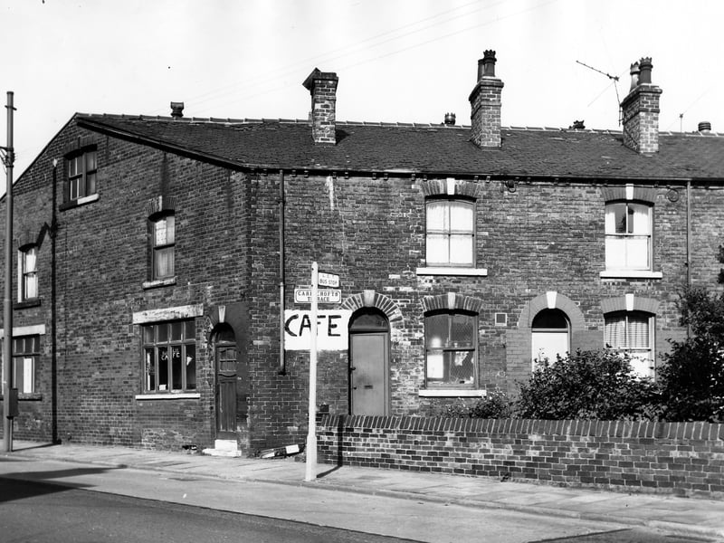 On the left of the image is number 234 Tong Road, a cafe with a chiropody practise at number 236 on the far left. On the far right, a row of back-to-back terraced houses on Carr Crofts Terrace. Pictured in September 1966.