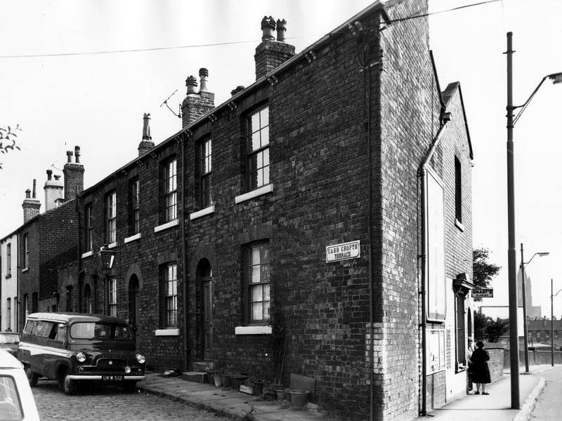 On the left of the image are three back-to-back terraced houses with a yard housing shared outside toilets on the far left. On the right is Tong Road with number 232 visible in the gable end of the terrace. This is home to the H & N Smart florists, providers of wedding bouquets and cremation sprays and wreaths. Pictured in September 1966.