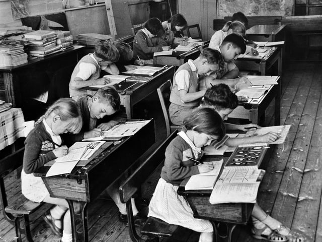 June 1961: This small group of pupils from Harley Church of England Primary School, were captured hard at work in class. With just 12 children on the school roll, the entire attendance is seen here during lessons. The caption notes that the school was due to close, with pupils soon to be moved to a new school at Cressage, marking the end of an era for this rural village classroom.