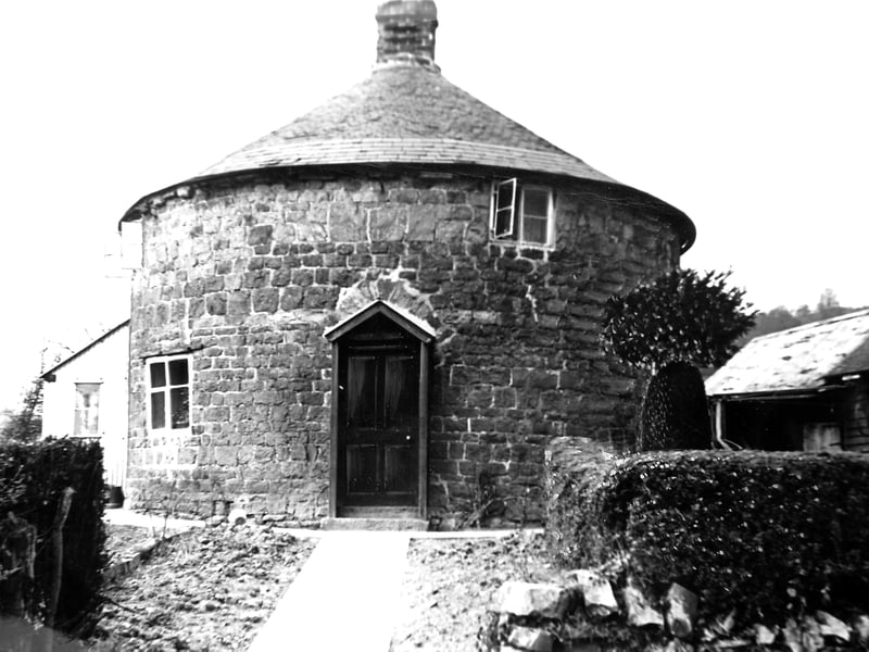 A distinctive round house at Aston-on-Clun, photographed in March 1961, with its unusual “no corners here” design standing out in this charming Shropshire village scene.