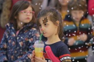 [caption id="attachment_195113" align="alignnone" width="300"] Alex O'Neill opted for a Rudolph the Red Nosed Reindeer design as many queued up to get their faces painted in bright colours.[/caption]
