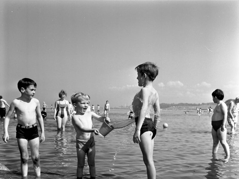 A wee boy splashes another youngster with water at Cramond, Edinburgh, in August 1970.