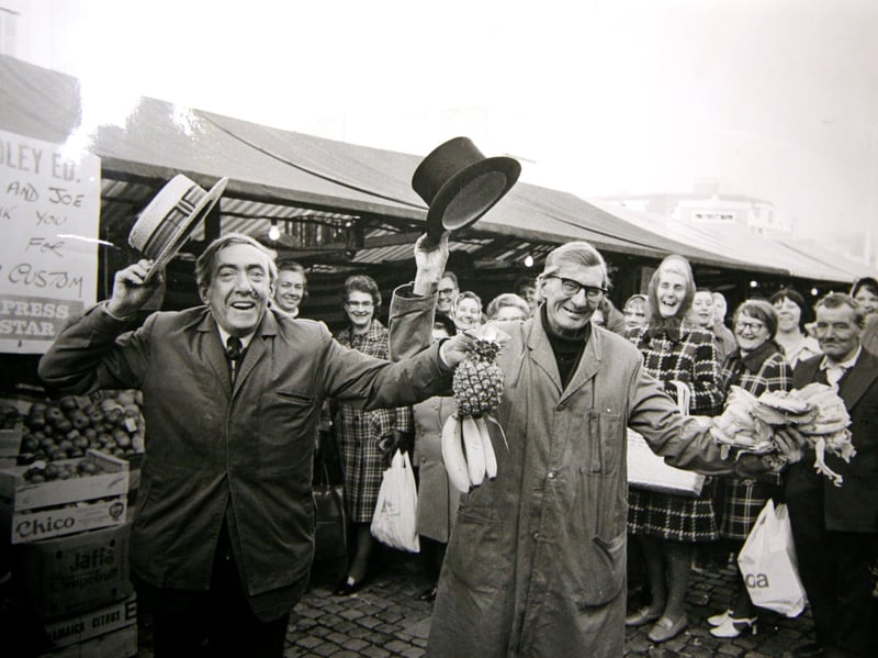 Brothers Joseph and James Brookes celebrate Joseph's retirement on Dudley Market in 1975. Pictured with their produce and raising their hats, the brothers mark the occasion in typically cheerful fashion. The photograph captures a glimpse of the characters and traditions that were once such a familiar part of market life. Do you remember the Brookes brothers, or shopping on Dudley Market in the 1970s?