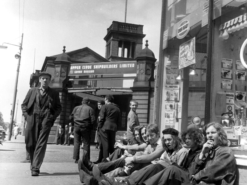 Shipyard workers eat their lunch in the sunshine outside the gates of the Govan division of the Upper Clyde Shipbuilders in June 1971