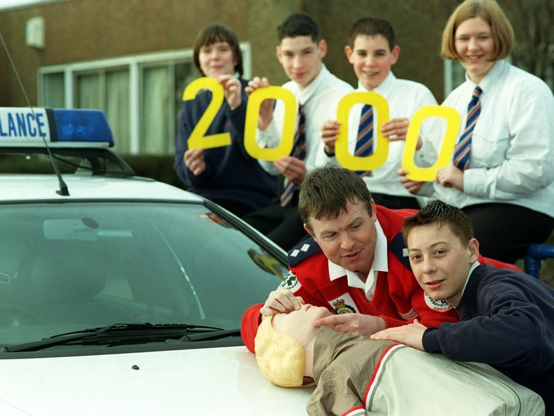 North Yorkshire Ambulance Service's resuscitation officer Paul Jackson (in red) with the 2,000th person to complete his kiss-of-life course James Morgan, right, a pupil at Brayton High School as his fellow pupils show the 2,000 milestone. Pictured in February 1999.