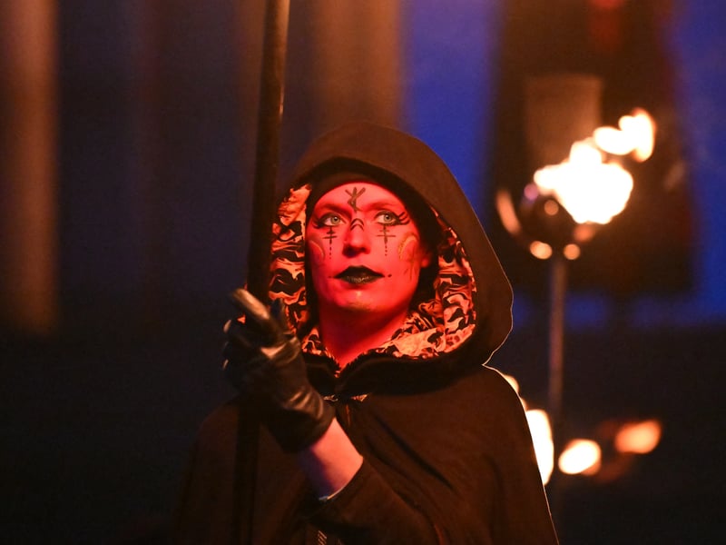 A performer helps light torches at Calton Hill.