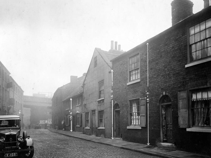 Wharf Street in October 1930. This street was between The Calls and Kirkgate. Towards the left the railway viaduct can be seen on Kirkgate. The City Engineers have marked the height of the buildings on this photo.