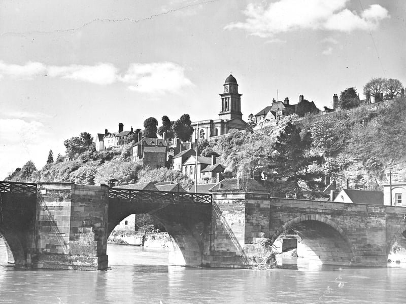 The photograph, taken in May 1955, shows Castle Walk as seen from the Low Town side of the River Severn, below the bridge.