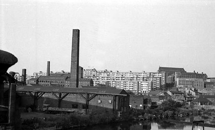 This view looks from Crown Point Bridge across the River Aire. To the left are industrial premises in Waddington's Yard and on East Street. In the background, Saxton Gardens can be seen.