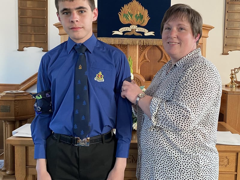Jamie having his presidents badge pinned on by his mum Heather.